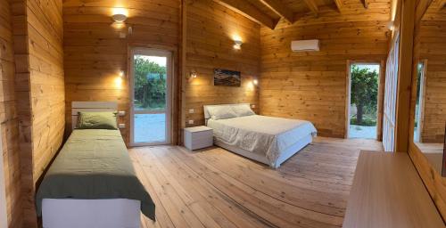 a bedroom with two beds in a wooden cabin at Agriturismo del Nonno in Centuripe
