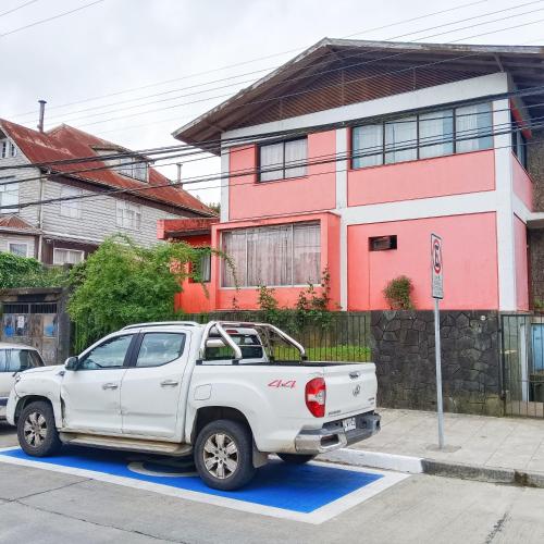 a white truck parked in front of a house at Hostel Adriana in Valdivia
