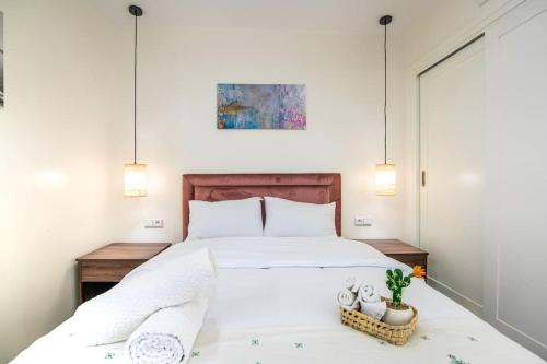 Un dormitorio con una gran cama blanca con dos luces. en Modern Oasis in Central Agadir, en Agadir