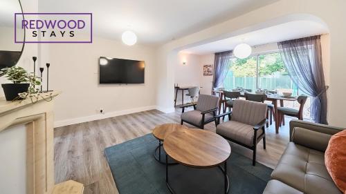 a living room with a couch and a table at 3 BEDROOM SERVICED HOUSE WITH FREE PARKING FOR 2 CARS, FREE WiFi, PERFECT FOR BUSINESS STAYS, FAMILIES, RELOCATIONS, EXTENDED STAYS, AND EMERGENCY ACCOMMODATION by REDWOOD STAYS in Camberley