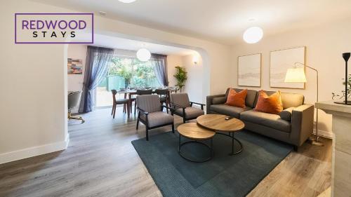 a living room with a couch and a table at 3 BEDROOM SERVICED HOUSE WITH FREE PARKING FOR 2 CARS, FREE WiFi, PERFECT FOR BUSINESS STAYS, FAMILIES, RELOCATIONS, EXTENDED STAYS, AND EMERGENCY ACCOMMODATION by REDWOOD STAYS in Camberley