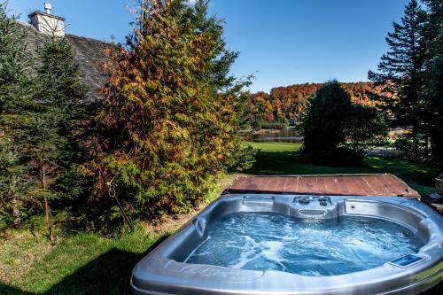 a hot tub in a yard next to a tree at Royal Laurentien in Mont-Blanc