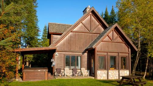 a log cabin with a deck and a grill at Royal Laurentien in Mont-Blanc