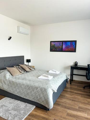 a bedroom with a large bed and a desk at Aquarius Stawy 3 in Grodzisk Mazowiecki