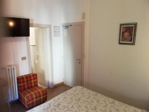 a hotel room with a bed and a chair at Hotel Gufo in Bormio