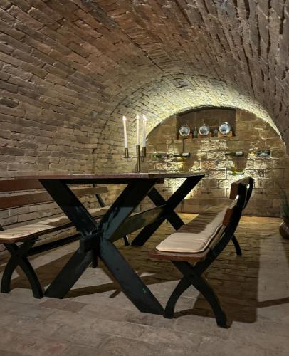 a table and a bench in a room with a brick wall at East Mountain Villa in Batina