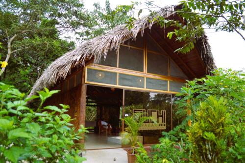 a bamboo house with a thatched roof at Suchipakari Amazon Eco -Lodge & Jungle Reserve in Puerto Misahuallí