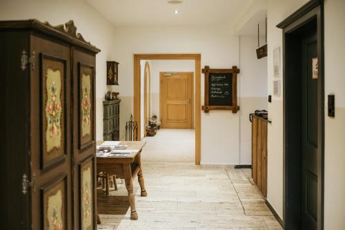 a hallway with a table and a chalkboard in a room at Pension Baranekhof - closest to the Kitzsteinhorn Ski Resort in Kaprun