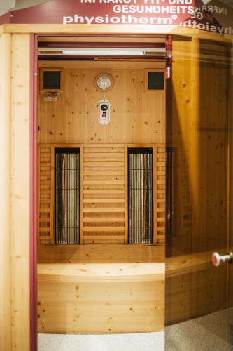 a wooden wall with four windows in a building at Pension Baranekhof - closest to the Kitzsteinhorn Ski Resort in Kaprun