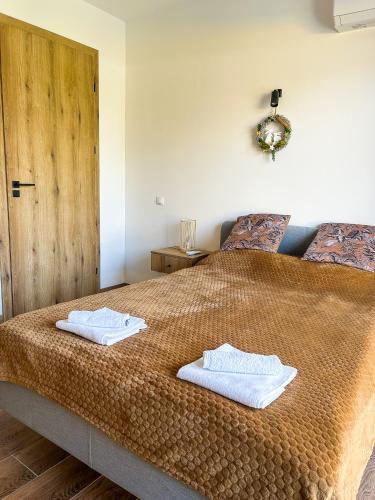 a bedroom with a bed with two towels on it at Aquarius Stawy 4 in Grodzisk Mazowiecki