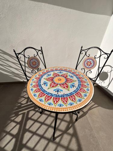 a table with a colorful plate on top of two chairs at Airport Capodichino Home By Pagnotta in Naples