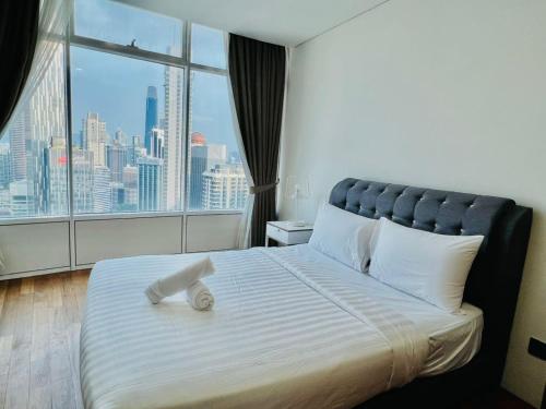 Un dormitorio con una cama grande con una ventana grande. en KLCC Vortex Suites Residence, en Kuala Lumpur