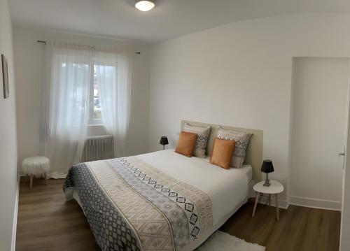 une chambre blanche avec un grand lit et une fenêtre dans l'établissement Au Sunrise T4, à Angoulême