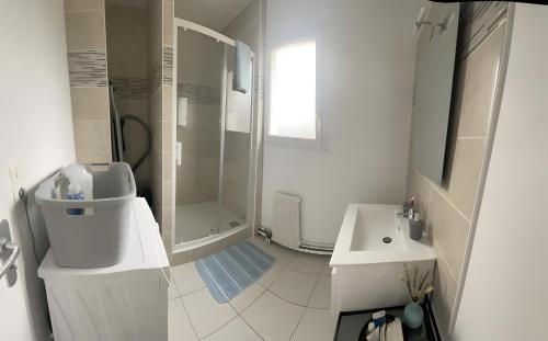 アングレームにあるAu Sunrise T4のシャワーと洗面台を備えた白いバスルーム