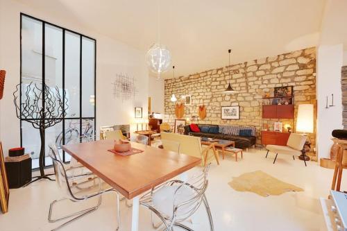 un salon avec une table et des chaises en bois dans l'établissement Spacious Vintage Duplex Flat - Gare du Nord, à Paris
