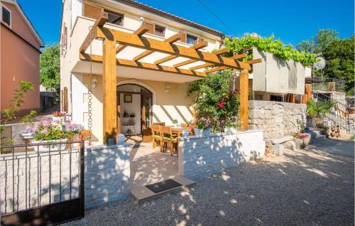 a house with a wooden pergola and a table at 2 Bedroom Amazing Home In Sveti Vid in Sveti Vid-Miholjice