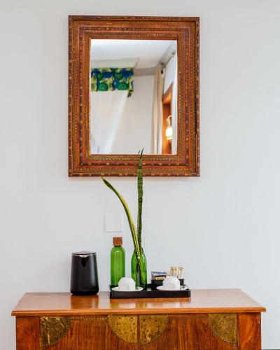 a mirror on top of a wooden table with a vase at The Seyyida Hotel and Spa in Zanzibar City