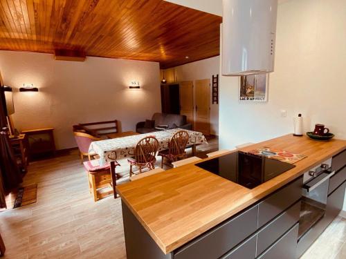 une cuisine et un salon avec une table et des chaises dans l'établissement Appartement rénové proche pistes avec terrasse et parking, 3 ch, 8 pers - FR-1-459-185, à La Clusaz