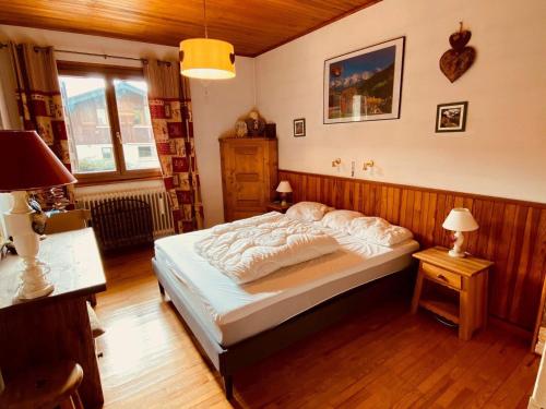 une chambre avec un grand lit dans une pièce dans l'établissement Appartement rénové proche pistes avec terrasse et parking, 3 ch, 8 pers - FR-1-459-185, à La Clusaz