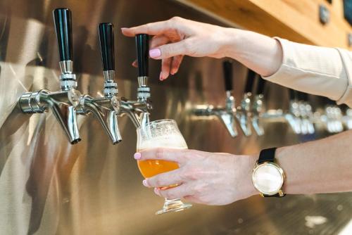 a person is holding a glass of beer at Holiday Inn Express & Suites Nashville West End - Univ Area by IHG in Nashville