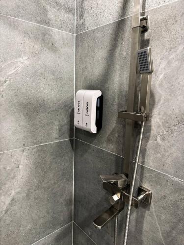 a shower with a soap dispenser on a wall at DOSTYK Hotel in Zyryanovsk
