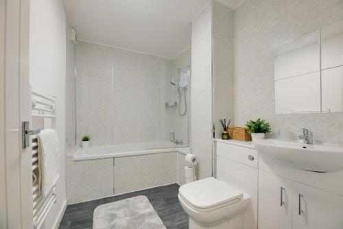 a white bathroom with a toilet and a sink at Central 3 bedroom Apartment & Free Parking- Ideal 4 long stays in Newcastle upon Tyne