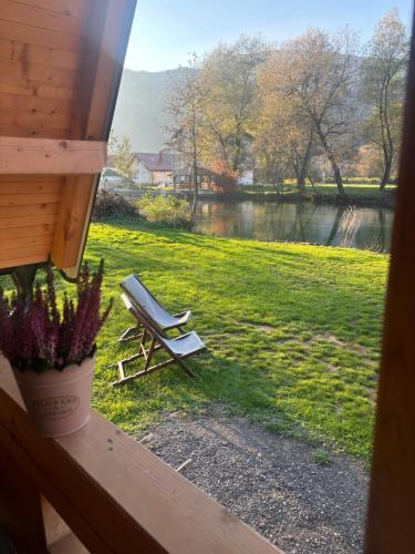 a bench sitting on the grass near a window at Bungalow Jajce 2 in Jezero