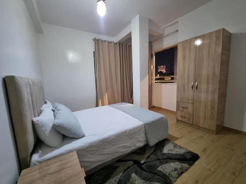 a bedroom with a bed and a dresser in it at Spacious and Modern 2BR Apartment Rabat center in Rabat