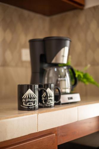 a coffee maker and two mugs on a counter at In Wotoch Departamentos con Estacionamiento in Valladolid