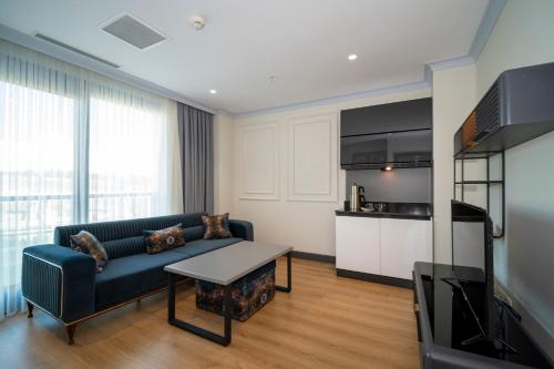 a living room with a couch and a tv at Rusel Park Residence in Bahcesehir
