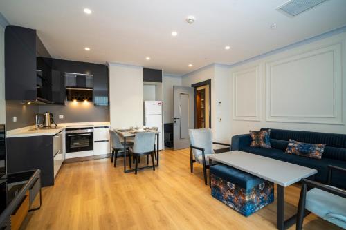 a living room with a blue couch and a kitchen at Rusel Park Residence in Bahcesehir