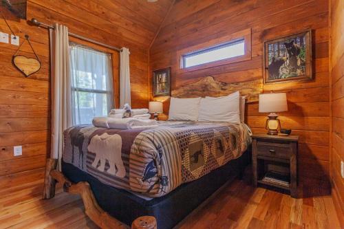 a bedroom with a bed in a log cabin at Cozy Cub at Deep Creek in Bryson City
