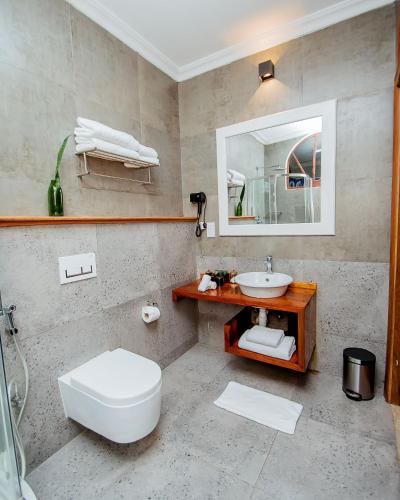 a bathroom with a white toilet and a sink at The Seyyida Hotel and Spa in Zanzibar City