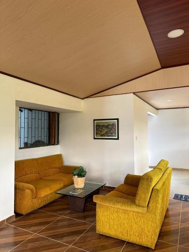 a living room with two couches and a table at Finca La Esperanza in Tibasosa