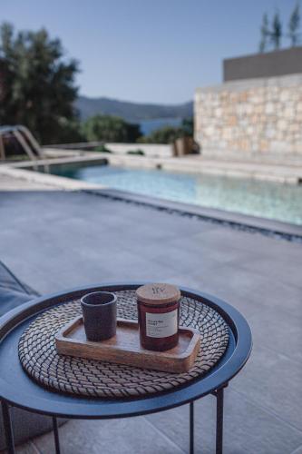 a tray with a cup and a coffee cup on a table near a pool at Nima Residences in Paleros