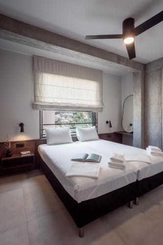 a bedroom with a large white bed with a ceiling fan at Nima Residences in Paleros