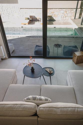 a living room with a couch and a swimming pool at Nima Residences in Paleros