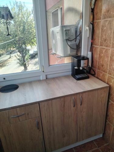 a kitchen with a counter with a microwave and a window at Garsoniera in Craiova