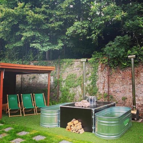 a grill in a yard with chairs and a table at Vakantiehuis L'Antoniade in Flobecq