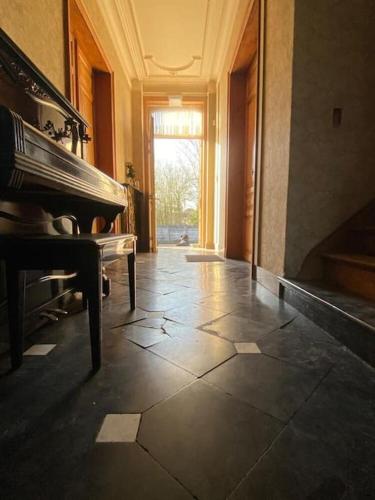 a hallway with a grand piano in a building at Vakantiehuis L'Antoniade in Flobecq