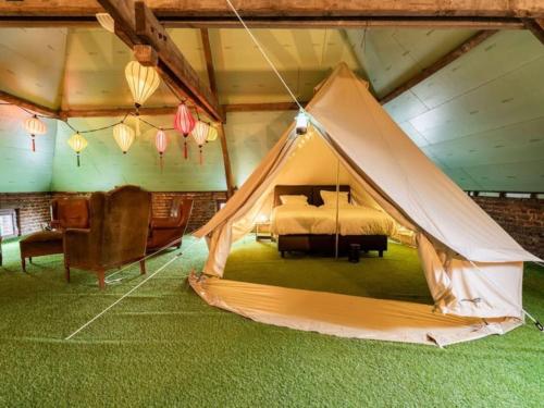 a bedroom with a bed and a tent at Vakantiehuis L'Antoniade in Flobecq