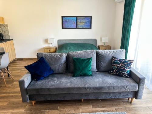 a gray couch with pillows in a living room at Aquarius Stawy Walczewskiego 6 in Grodzisk Mazowiecki