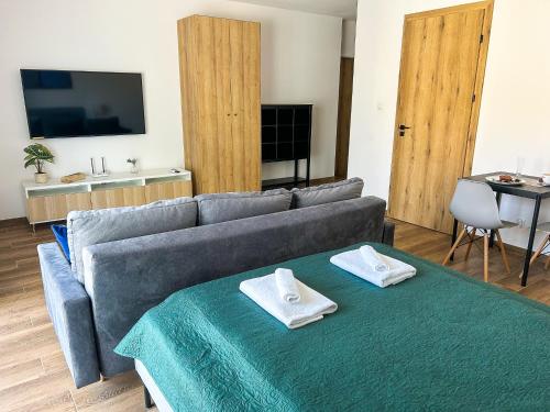 a living room with a couch and a table with towels at Aquarius Stawy Walczewskiego 6 in Grodzisk Mazowiecki