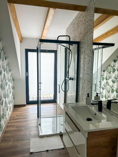 a bathroom with a glass shower and a sink at Aquarius Stawy 10 in Grodzisk Mazowiecki