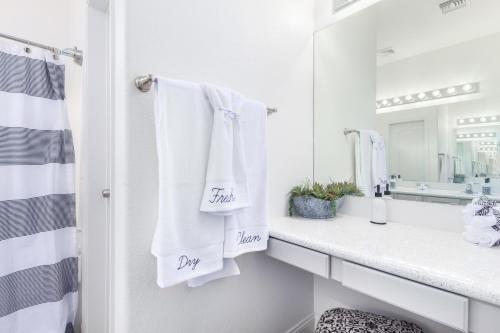 a bathroom with white towels and a mirror at San Michelle Luxury Escape -Mesa in Mesa