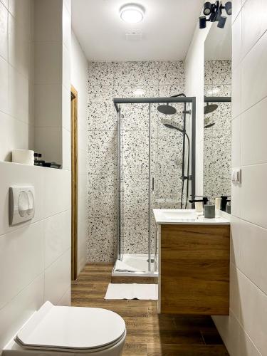 a bathroom with a shower and a toilet and a sink at Aquarius Stawy 11 in Grodzisk Mazowiecki