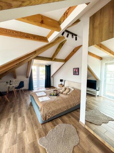 a bedroom with a large bed and wooden ceilings at Aquarius Stawy 11 in Grodzisk Mazowiecki