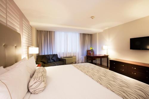 a hotel room with a large bed and a television at Krystal Satelite Maria Barbara in Mexico City