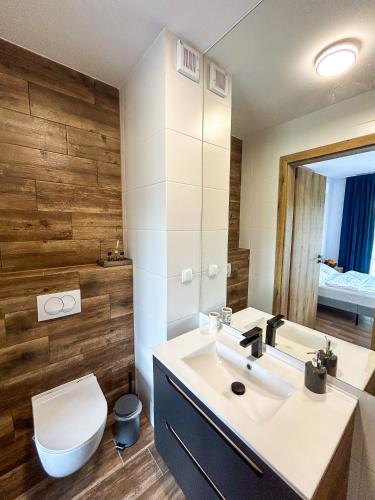 a bathroom with a white sink and a toilet at Aquarius Stawy Walczewskiego 8 in Grodzisk Mazowiecki