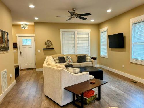 a living room with a couch and a ceiling fan at Urban Retreat Downtown Gem Walk Everywhere Train View Mountain View Near National Park Entrance in Bryson City